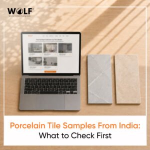 Laptop showing Wolf tile collections website next to two porcelain tile samples on a desk, porcelain tile samples from India guide for importers 2026