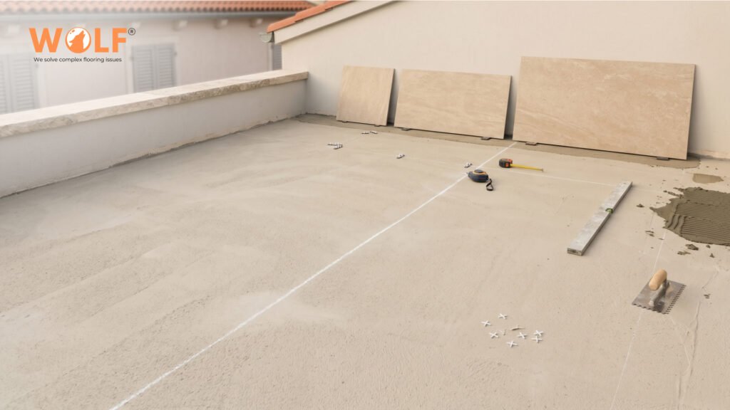 Outdoor terrace mid-installation with matte porcelain tiles staged for layout on Croatian coastal property