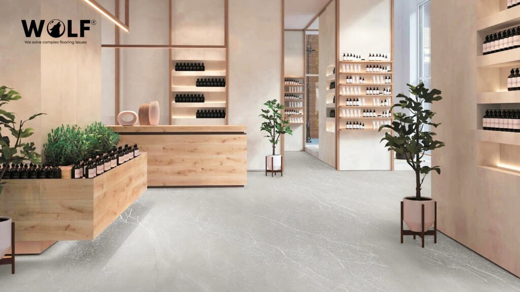 Large-format grey stone-look porcelain floor tiles installed in a Dutch retail showroom interior